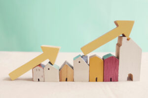 Wooden model houses with yellow arrows up.