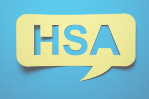 Yellow paper speech bubble with "HSA" cut out of the middle on a blue background