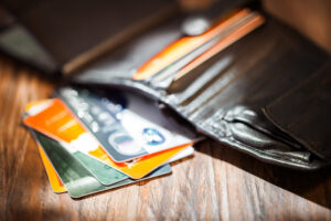 An open leather wallet reveals multiple premium credit cards