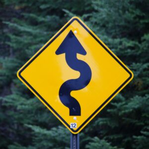 Yellow yield sign warning drivers of twists in the road representing yield curves