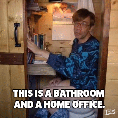 Man crouches in tiny modified closet space saying, "This is a bathroom and a home office."
